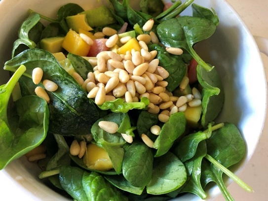 Salade van babyspinazie met avocado en pijnboompitten